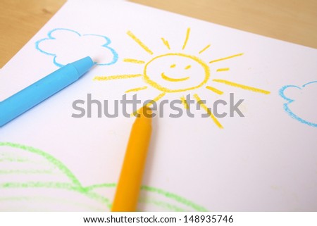 Cute childish drawing by wax crayons. Sun and landscape