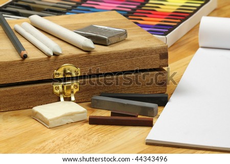 Drawing professional tools - paper stumps, charcoal pencil and sticks on wooden box. Pastels set