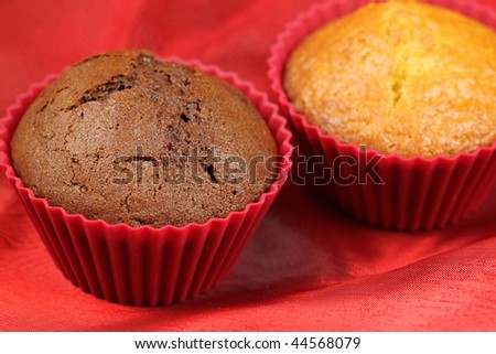 Bright and dark muffins in red molds on red silk. Symbolic love - black and white
