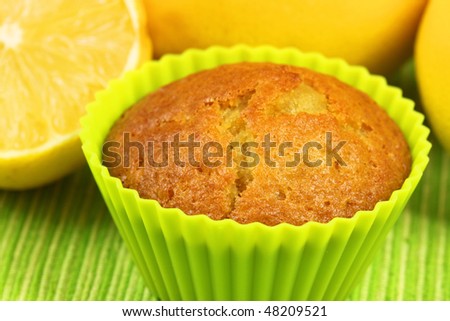 Closeup of fresh lemon cupcake with yellow lemons in background