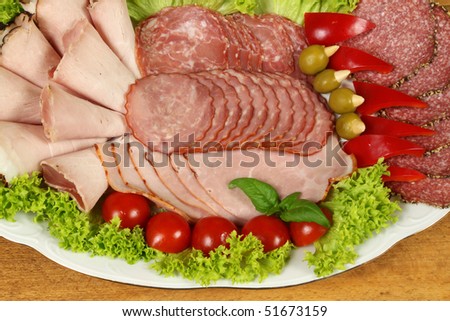 Banquet plate with slices of ham and sausage with garnish vegetables