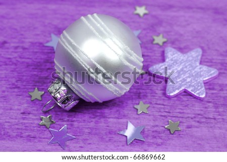 Bright glass bauble ornament and stars. Purple background