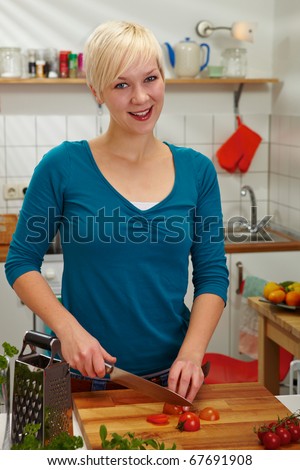Woman slicing tomatoes on carving board with knife