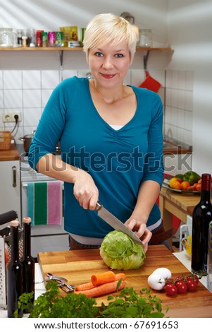 Woman slicing fresh iceberg lettuce on cutting board