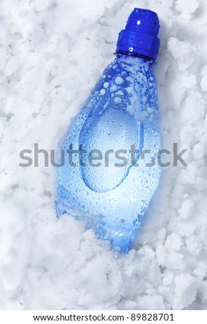 Blue soda bottle in crushed ice with back light