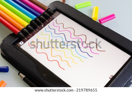 Colorful set of maker pens with squiggly lines drawn by each one on a sheet of white paper to show the vibrant color palette in the colors of the rainbow or spectrum