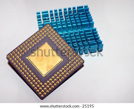 computer CPU from the downside with pins and core displayed. in the background a passive CPU heatsink