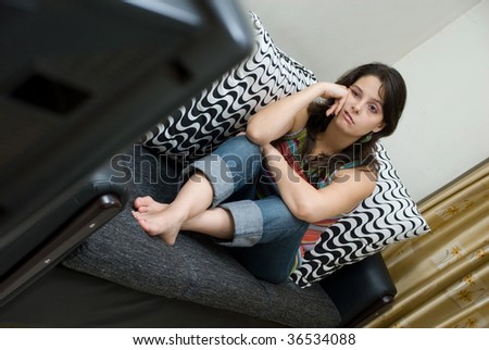 Bored woman watching tv sitting