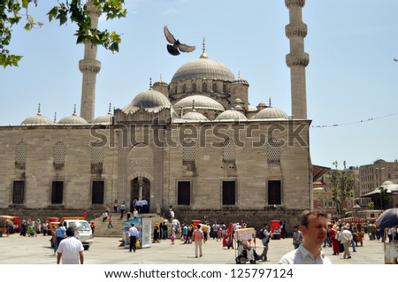 ISTANBUL, TURKEY - JUNE 03: Tourists near Valide Sultan Mosque on June 03, 2012 in Istanbul, Turkey. Valide Sultan Mosque is most famous as Yeni Cami and was built during 1597-1663 by Ottoman.