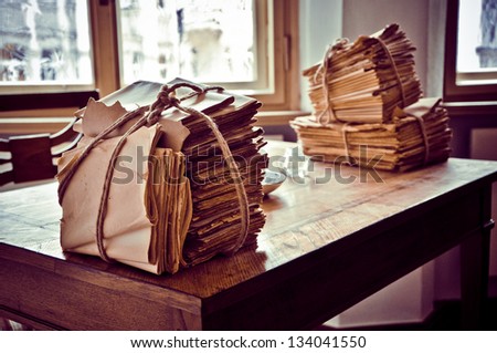 A stack of aged letters on a wooden table