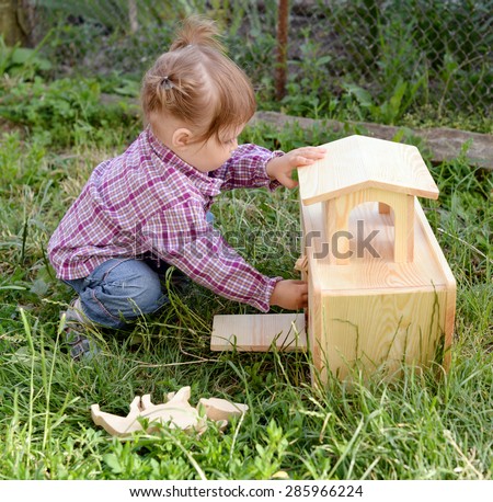 Cute little girl playing with a wooden Noah\'s ark