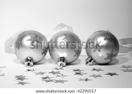 Three silver christmas balls in stars with silver ribbon