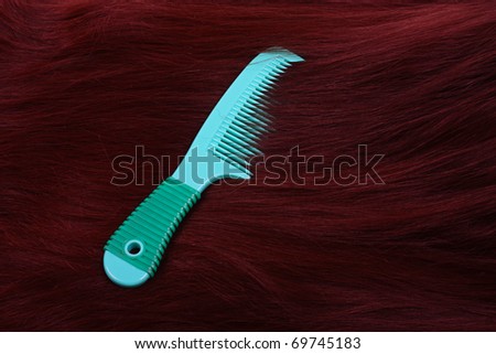 Texture of brunette long hair with green comb
