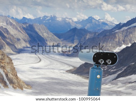 concept for for look out, observation and forecast:  binoculars view over panorama view above Aletsch glacier starting to disappear in clouds, Switzerland