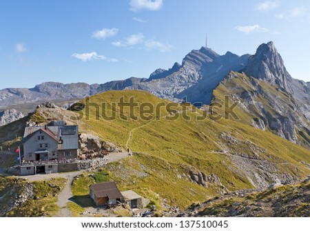 hiking path through rocky mountainous ridges with rest house and leading up mountain Saentis, Switzerland