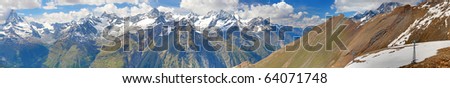 long panorama of the alpine mountain range seen from mountain Rothorn seen towards Zermatt in Switzerland with glacier and Matterhorn in summer