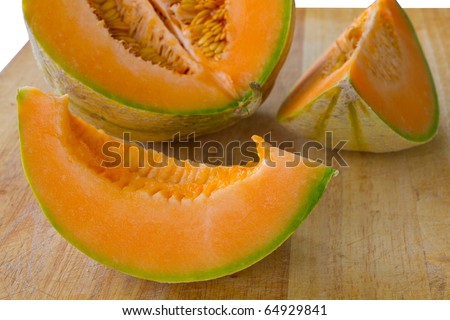 sliced piece of fresh orange cantaloupe melon on wooden carving board