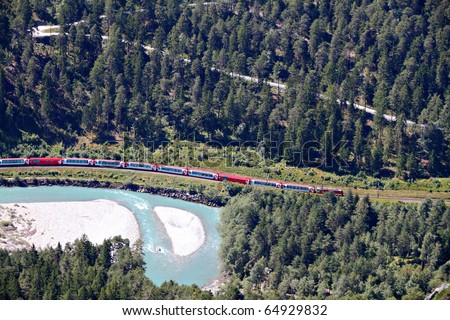 famous red train Glacier Express drives alongside river Rhine in canyon
