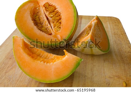 sliced up fresh orange cantaloupe melon on wooden carving board