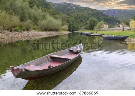 boats on a quiet, calm, clear mountain river running in green nature.