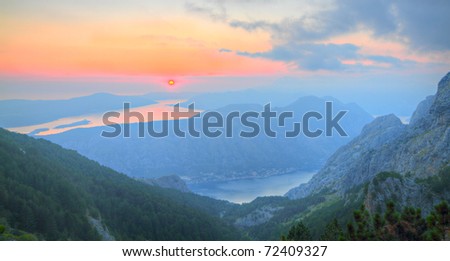 UNESCO World Heritage Site bay of Kotor with high mountains plunge into adriatic sea at sunset, Montenegro