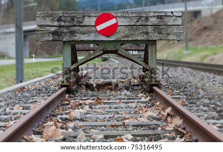 wooden buffer stop with red stop sign ending rail tracks concept for limit, limitation restriction boundary, prohibited, end , border