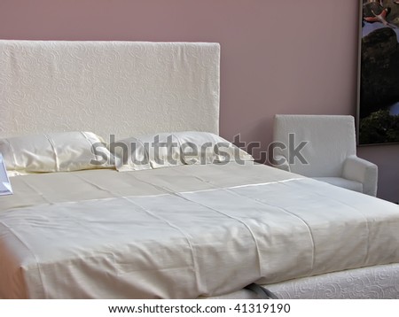 white bedroom. king size bed with white sheets.