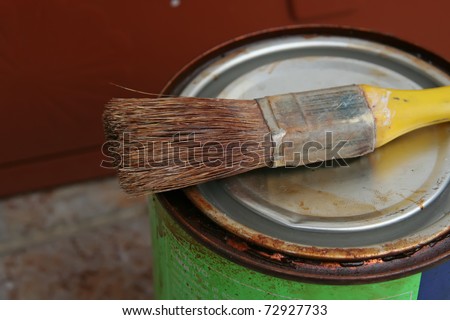Brush and wood paint. Brush and can of paint.