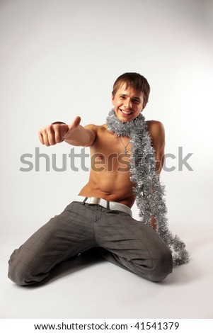The undressed guy attractive on a belt with a tinsel on a neck shows gesture \