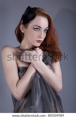 Beautiful red-haired girl with her hair in a light cloak over his naked body