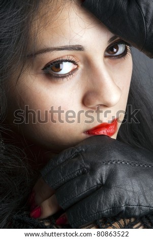 close-up portrait of young woman with red lips and big eyes on a black background
