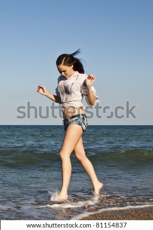 Beautiful woman in shorts running on the beach