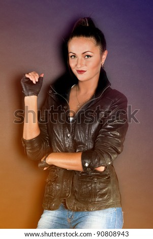 Young brunette lady in black jacket posing on grey background