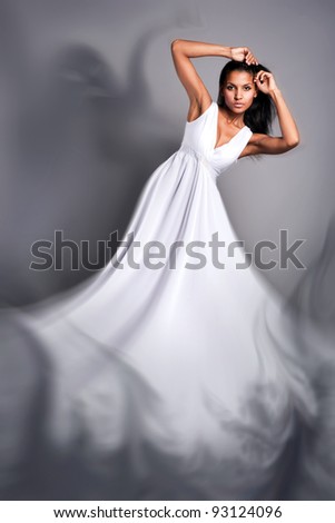 portrait of a beautiful dark-skinned woman in a white dress in the studio