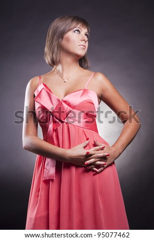 closeup portrait of brunette girl in pink dress in studio