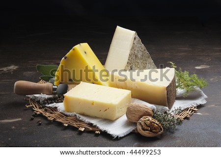 A Stone table in a farm with cheeses nuts and spices