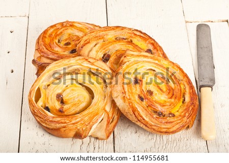 Danish or French pastries on a rustic board with a knife
