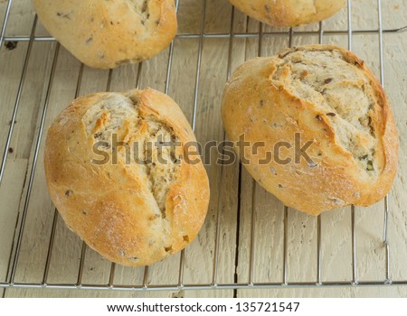 Freshly baked bread rolls on a cooling tray