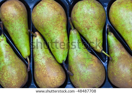 Pears aligned in a tray display at a supermarket