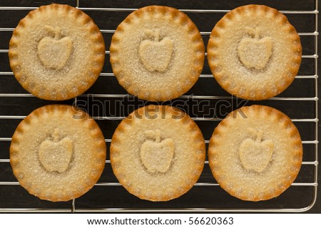 Apple pies on a cooling tray sat on a slate background