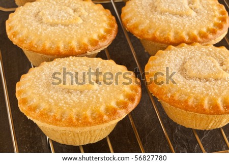Four Apple Pies on a cooling tray with focus on the center of the left front pie