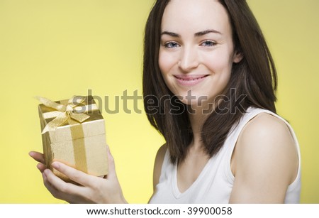 Young woman presenting a golden shinny gift box