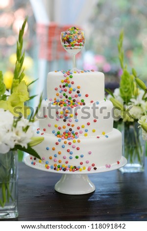 Delicious white wedding cake decorated colorful candies