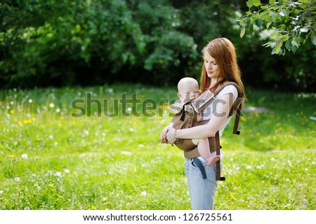 Young mother and her little baby in a carrier