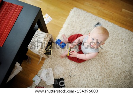 Adorable baby girl making a mess at home