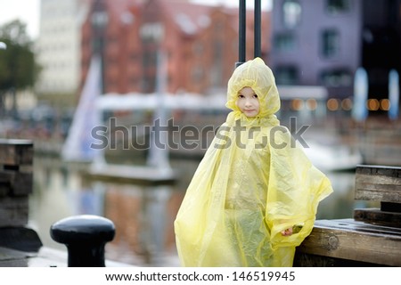 Adorable little girl in yellow rain coat