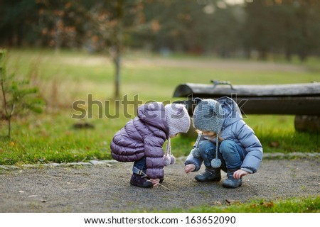 Two sisters playing outdoors on early spring or late autumn