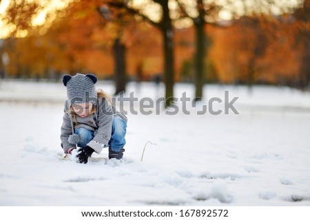 Little girl having fun on winter day in a city