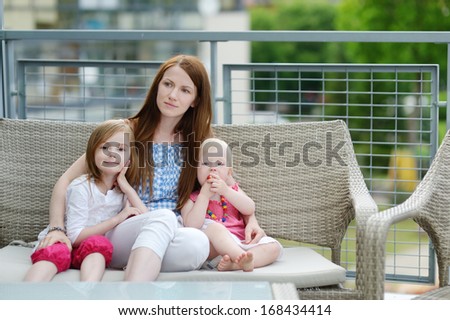 Young mother and her daughters outdoors at summer