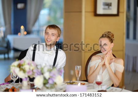 Happy bride and groom at the reception table